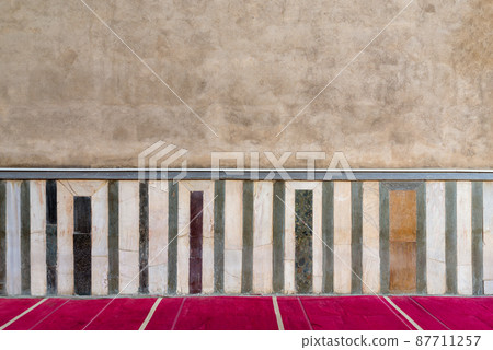 Old grunge stone wall decorated with colorful marble pattern Old grunge stone wall decorated with colorful marble pattern 87711257