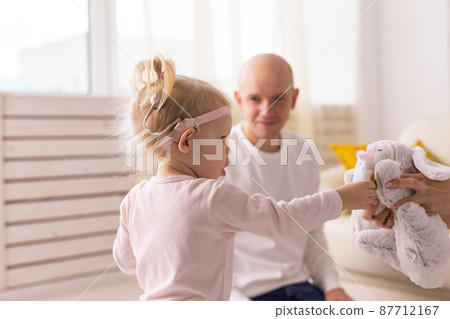 Baby with cochlear implants playing with her father at home. Deafness and medical technology concept 87712167