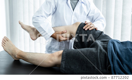 Male patient lying on the bed to getting healing treatment and rehabilitation injured knee and legs Male patient lying on the bed to getting healing treatment and rehabilitation injured knee and legs 87712202