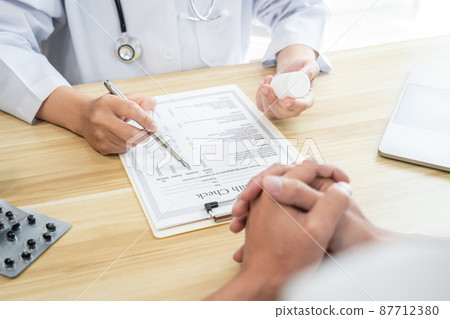 Doctor discussing with the patient using the medicine something and recommend treatment methods, Presenting results on report, Medicine and Healthcare concept Doctor discussing with the patient using the medicine something and recommend treatment methods, Presenting results on report, Medicine and Healthcare concept 87712380