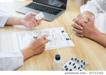 Doctor discussing with the patient using the medicine something and recommend treatment methods, Presenting results on report, Medicine and Healthcare concept Doctor discussing with the patient using the medicine something and recommend treatment methods, Presenting results on report, Medicine and Healthcare concept 87712382