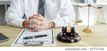 Male lawyer working with litigation contract paper documents of the estate lawsuit, Law books and wooden gavel on table office 87712392