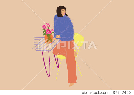 Beautiful stylish woman standing relaxed by the table with vase of flowers 87712400