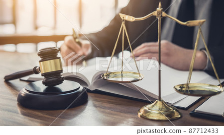 Male lawyer or judge working with contract papers, Law books and wooden gavel on table in courtroom, Justice lawyers at law firm, Law and Legal services concept 87712433