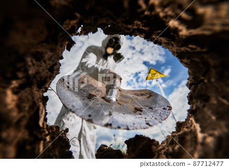 View from earth pit. Selective focus on shovel equipment using during ecological experiment in radioactive dangerous environment, blurred male scientist have biological research in nuclear area. View from earth pit. Selective focus on shovel equipment using during ecological experiment in radioactive dangerous environment, blurred male scientist have biological research in nuclear area. 87712477