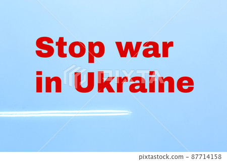 Stop the war in Ukraine. Inscription on a background of blue sky in red letters. Trace of an airplane in the sky. Russia's invasion of Ukraine. Stop the war in Ukraine. Inscription on a background of blue sky in red letters. Trace of an airplane in the sky. Russia's invasion of Ukraine. 87714158