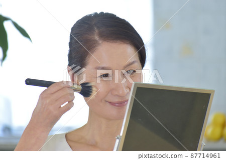 60多歲的女人照鏡子用刷子打粉 60多歲的女人照鏡子用刷子打粉 87714961