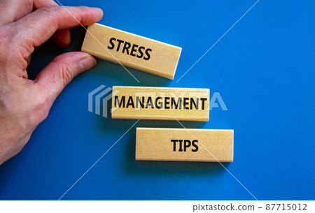 Stress management tips symbol. Wooden blocks with words 'Stress management tips'. Beautiful blue background. Doctor hand. Psychological, business and stress management tips concept. Copy space. 87715012