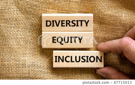 Diversity equity inclusion symbol. Concept words diversity equity inclusion on blocks on beautiful canvas table canvas background. Businessman hand. Business, diversity equity inclusion concept. 87715013