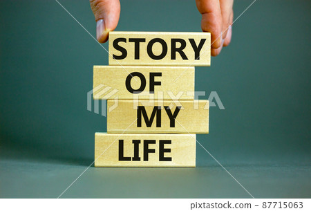Story of my life and storytelling symbol. Concept words Story of my life on wooden blocks. Businessman hand. Beautiful grey table grey background. Story of my life business concept. Copy space. Story of my life and storytelling symbol. Concept words Story of my life on wooden blocks. Businessman hand. Beautiful grey table grey background. Story of my life business concept. Copy space. 87715063