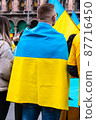 Young man wrapped in the Ukrainian flag in a protest against Russia invasion 87716450