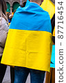 Young man wrapped in the Ukrainian flag in a protest against Russia invasion 87716454
