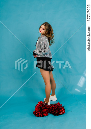 Young lady cheerleader posing in the studio, isolated on red and blue Young lady cheerleader posing in the studio, isolated on red and blue 87717003