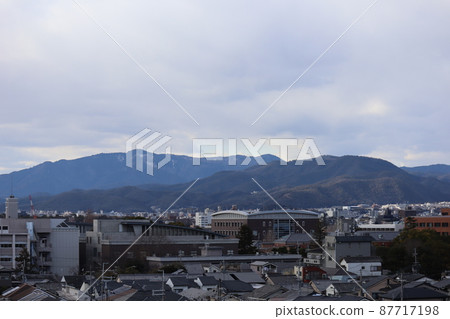 多雲的天空、山脈和城市景觀的景色 87717198