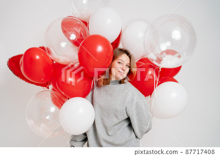 an blonde woman with balloons on a white background.  87717408