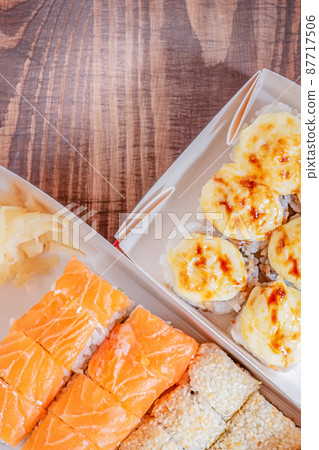 Japanese food rolls in paper boxes. Food delivery. 87717506