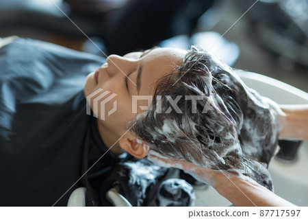 Woman having shampoo at a beauty salon Woman having shampoo at a beauty salon 87717597