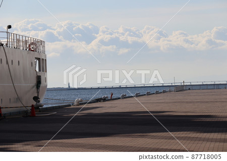 從大船停靠的港口濱海公園看到的碧海、小橋、燈塔、朦朧的山巒、雲霧、藍天的景色。 87718005