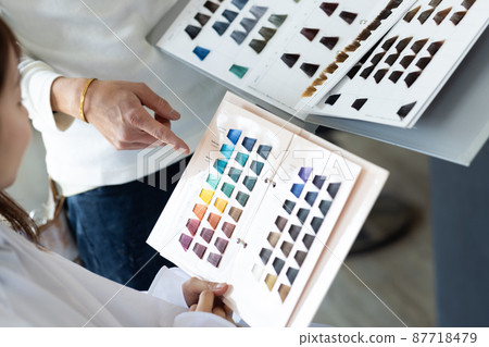 A woman getting a hair color at a beauty salon 87718479