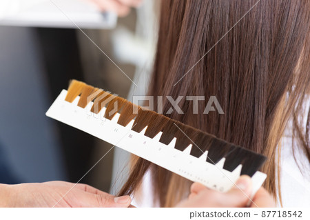 A woman getting a hair color at a beauty salon 87718542