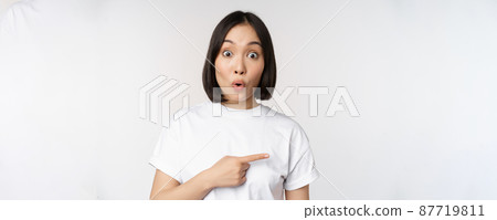 Portrait of surprised asian woman say wow, pointing right at amazing product offer, sale or logo, standing over white background Portrait of surprised asian woman say wow, pointing right at amazing product offer, sale or logo, standing over white background 87719811