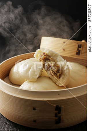 Hot meat bun freshly steamed in a bamboo steamer 87720207