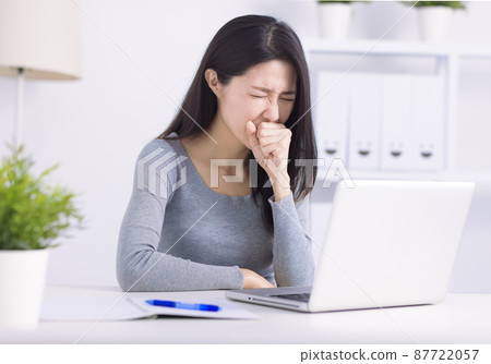 Sick young woman busy at laptop cough struggle 87722057