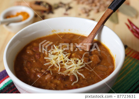 Bowl of Chili With Pinto Beans on Table With Peppers and Dry Beans in Background Bowl of Chili With Pinto Beans on Table With Peppers and Dry Beans in Background 87723631
