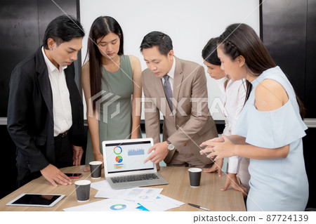 Young businessman present graph report and statistics of profit with finance on laptop. 87724139