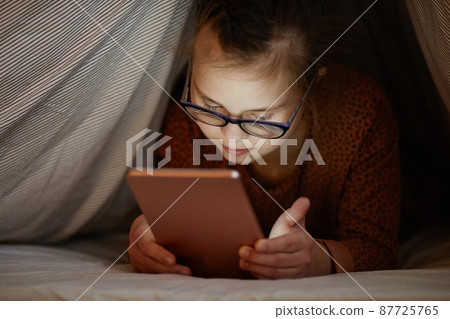 Girl with Down Syndrome using Smartphone at Night 87725765