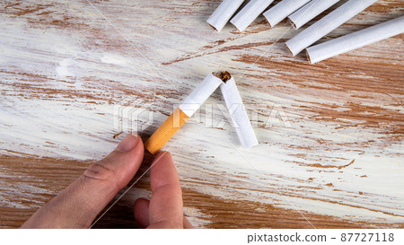 Quit smoking. Broken cigarette on a white painted wooden background 87727118