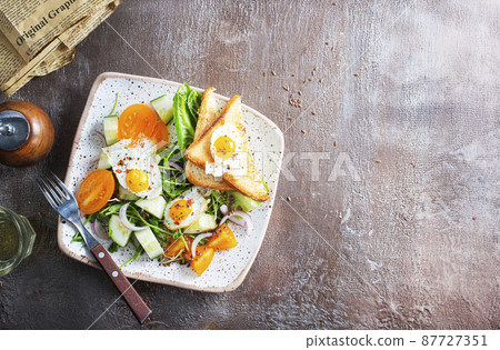 fried eggs with vegetables, top view, diet salad with quail eggs 87727351