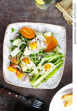 fried eggs with vegetables, top view, diet salad with quail eggs 87727353