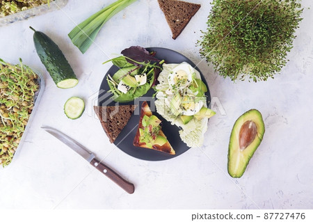 Salad of avocado, boiled eggs, leek, micro greens sprouts and arugula, on a plate on a light table, top view, flatly, natural ingredients, healthy food Salad of avocado, boiled eggs, leek, micro greens sprouts and arugula, on a plate on a light table, top view, flatly, natural ingredients, healthy food 87727476