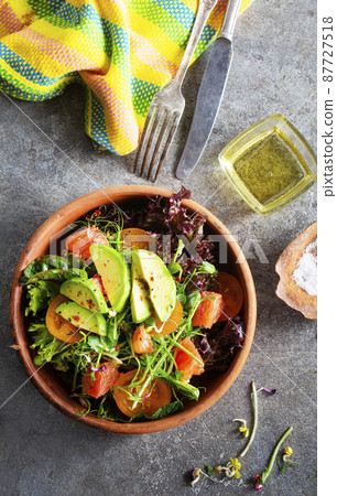 Healthy vegan salad, avocado, cucumber, tomato, radish, nuts and seeds. Girl in denim shirt holding a bowl of vegan salad Healthy vegan salad, avocado, cucumber, tomato, radish, nuts and seeds. Girl in denim shirt holding a bowl of vegan salad 87727518