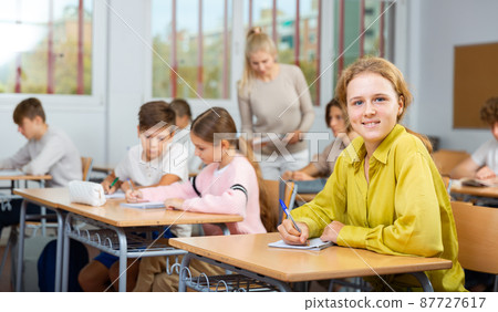 Teenage students are sitting at their desks Teenage students are sitting at their desks 87727617
