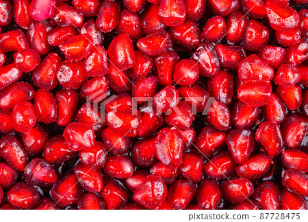 Ripe pomegranate fruits on the wooden background Ripe pomegranate fruits on the wooden background 87728475