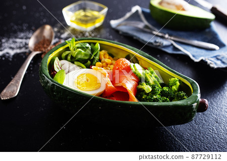 bowl with avocado, salmon, couscous and poached egg 87729112