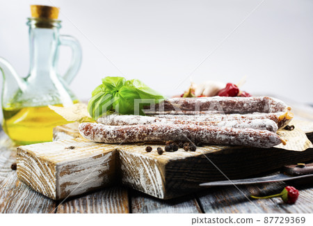 Traditional white salami sausage, sliced salami isolated on white background. Whole dry salami sausage stick. Traditional white salami sausage, sliced salami isolated on white background. Whole dry salami sausage stick. 87729369