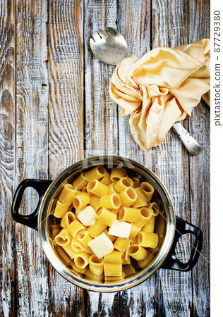 boiled pasta with butter in metal bowl 87729380
