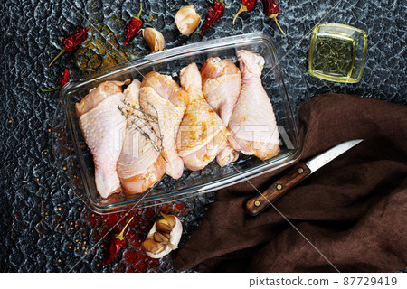 Raw uncooked chicken legs with ingredients for cooking 87729419