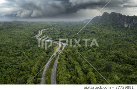 Top view of countryside road passing through the green forrest and mountain Top view of countryside road passing through the green forrest and mountain 87729891