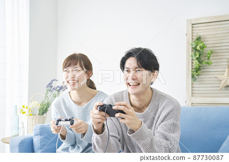 Men and women playing video games Men and women playing video games 87730087