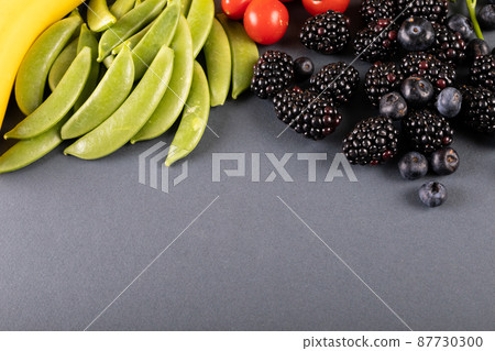 Close-up of blueberries and blackberries with vegetables on table with copy space Close-up of blueberries and blackberries with vegetables on table with copy space 87730300