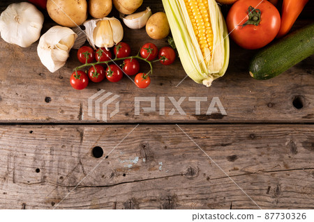 Directly above shot of cherry tomatoes with garlic, corn and vegetables on table with copy space Directly above shot of cherry tomatoes with garlic, corn and vegetables on table with copy space 87730326
