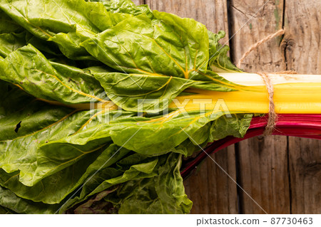 Overhead close-up of spinach bundle on wooden table 87730463