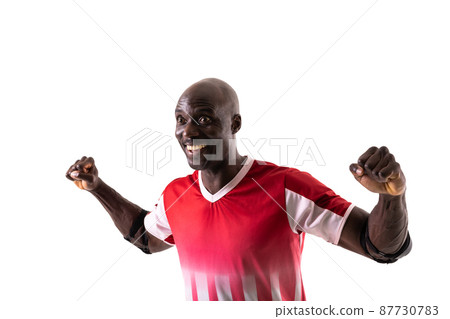 Excited young male african american handball player celebrating goal against white background Excited young male african american handball player celebrating goal against white background 87730783
