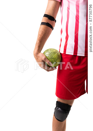 Midsection of young male caucasian handball player holding green ball against white background Midsection of young male caucasian handball player holding green ball against white background 87730796