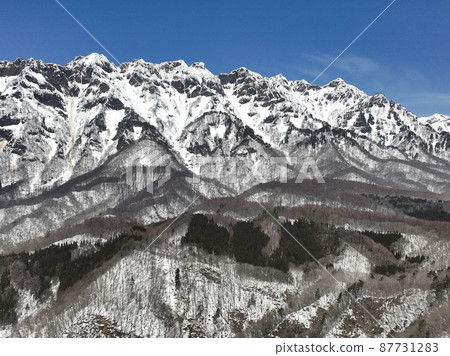 A magnificent view of the Togakushi Nishidake mountain range from the Daibo Pass in winter, Nagano City, Nagano Prefecture (aerial view by drone) A magnificent view of the Togakushi Nishidake mountain range from the Daibo Pass in winter, Nagano City, Nagano Prefecture (aerial view by drone) 87731283