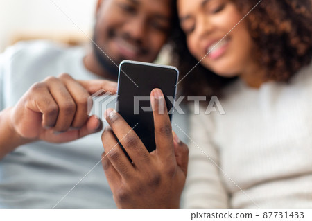 close up of happy couple with smartphone at home close up of happy couple with smartphone at home 87731433